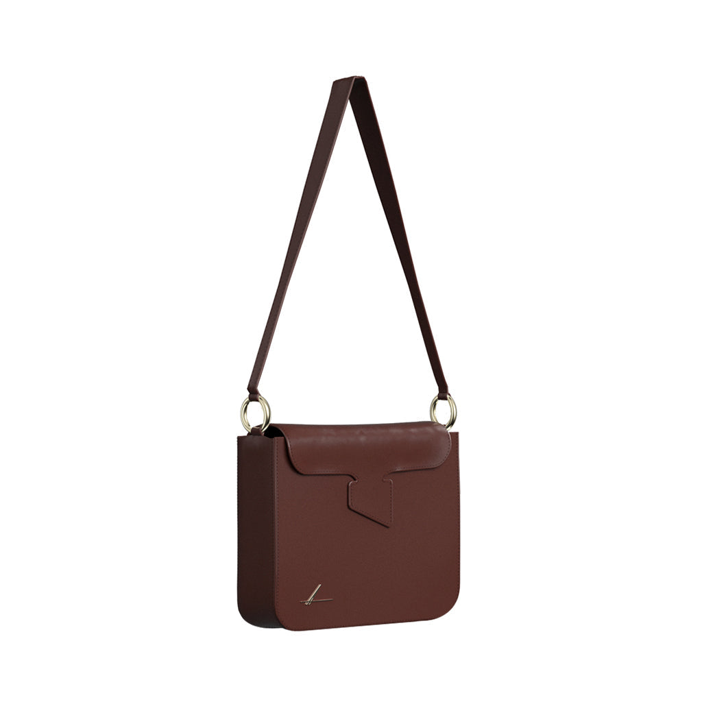 Brown leather shoulder bag with gold ring accents and flap closure