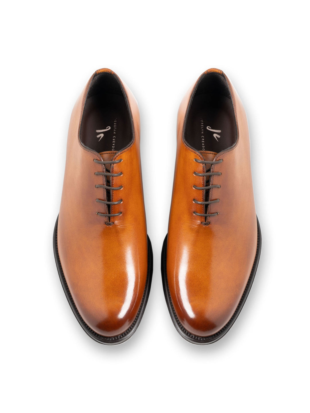 Brown leather Oxford dress shoes with black laces on a white background