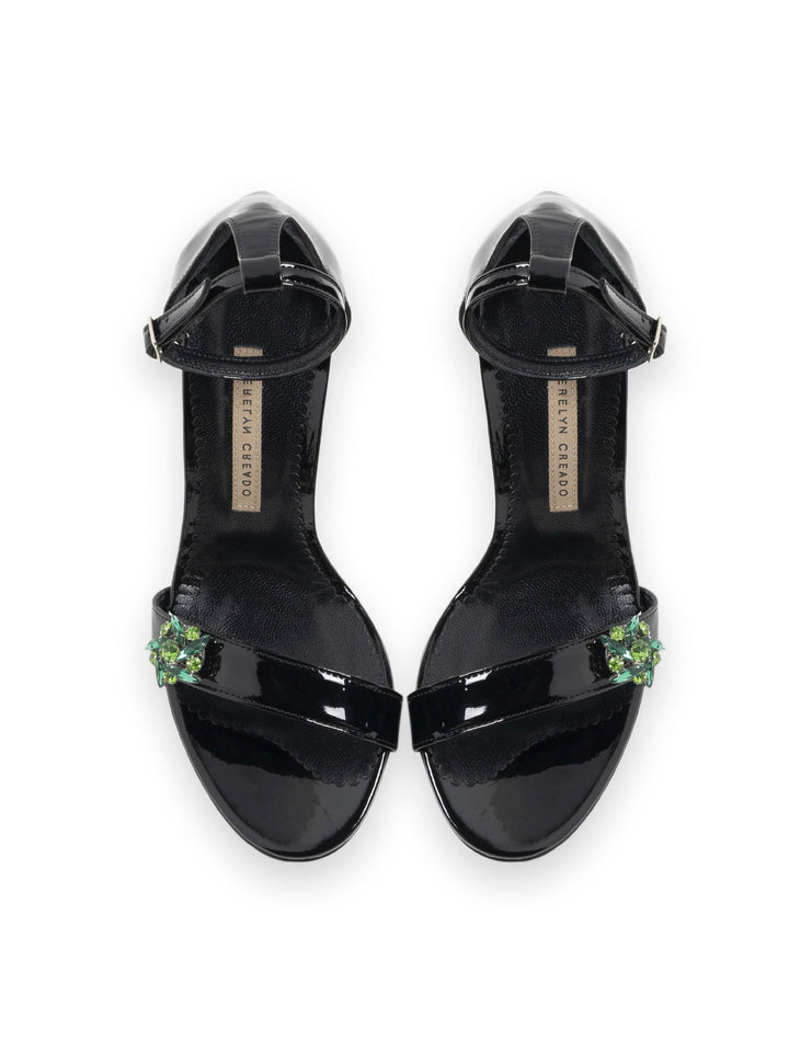 Black patent leather heels with green embellishments and ankle strap