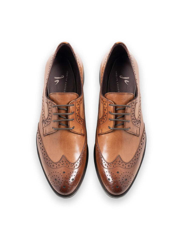 Brown leather brogue dress shoes with intricate perforated design