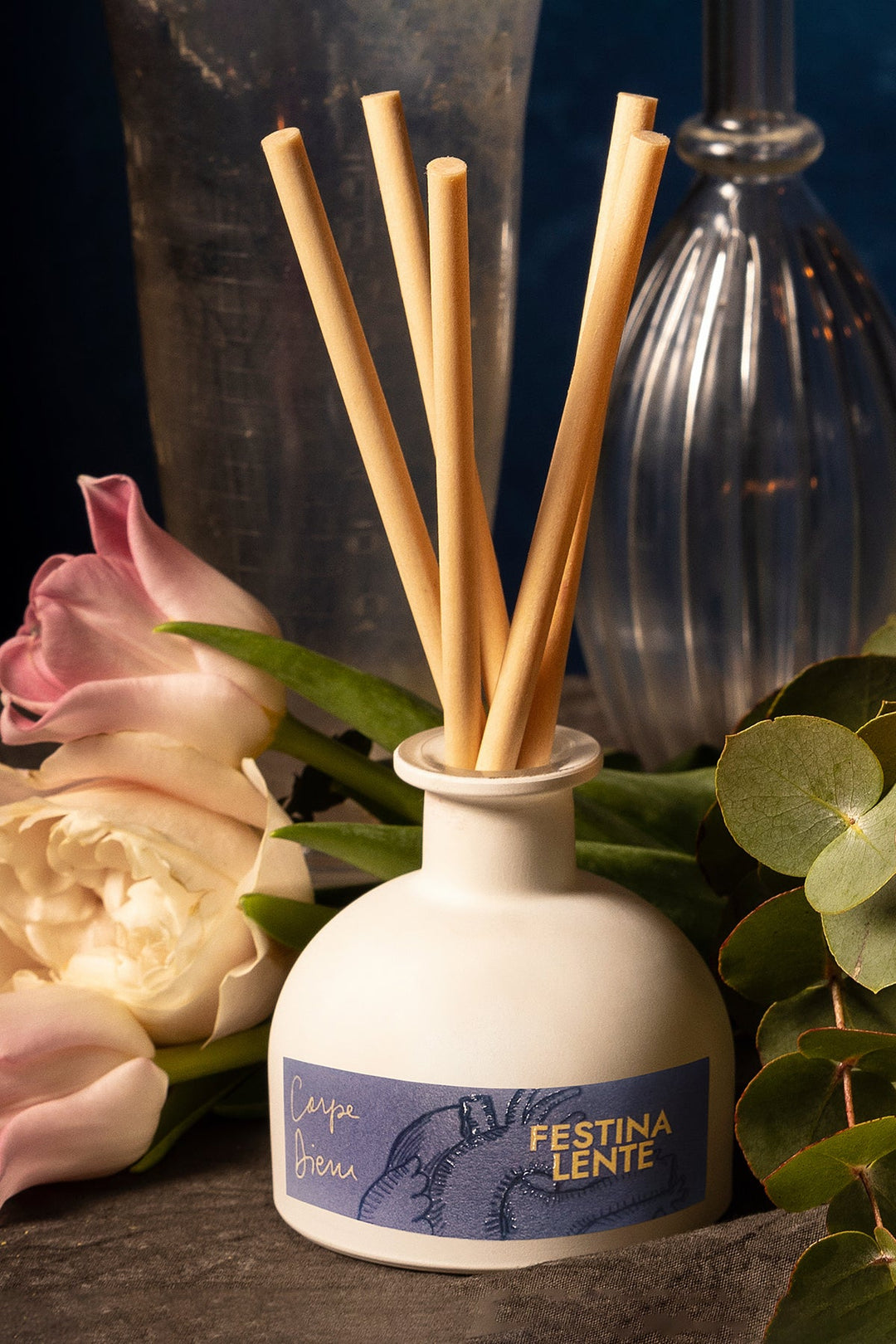 Aromatic reed diffuser with pink and white flowers in background