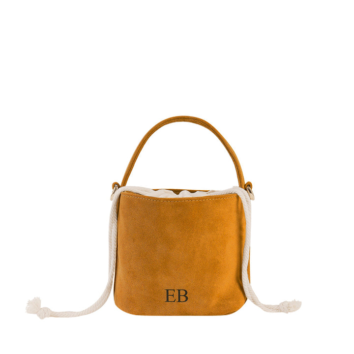 Mustard yellow leather bucket bag with white drawstring and single handle, featuring EB monogram