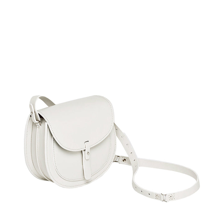 White leather crossbody bag with buckle strap and flap closure