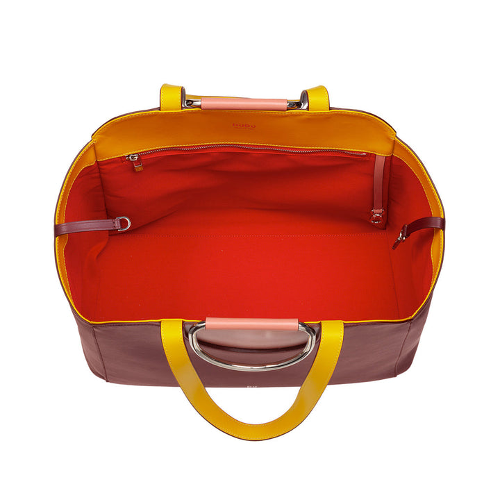 Top view of an open, empty, multicolored handbag with yellow handles