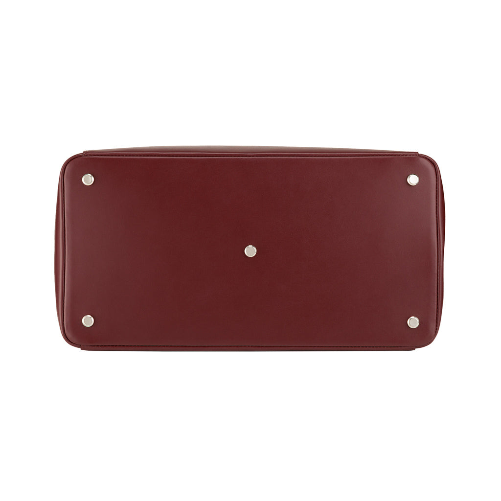 Bottom view of a chic maroon leather handbag with metal feet