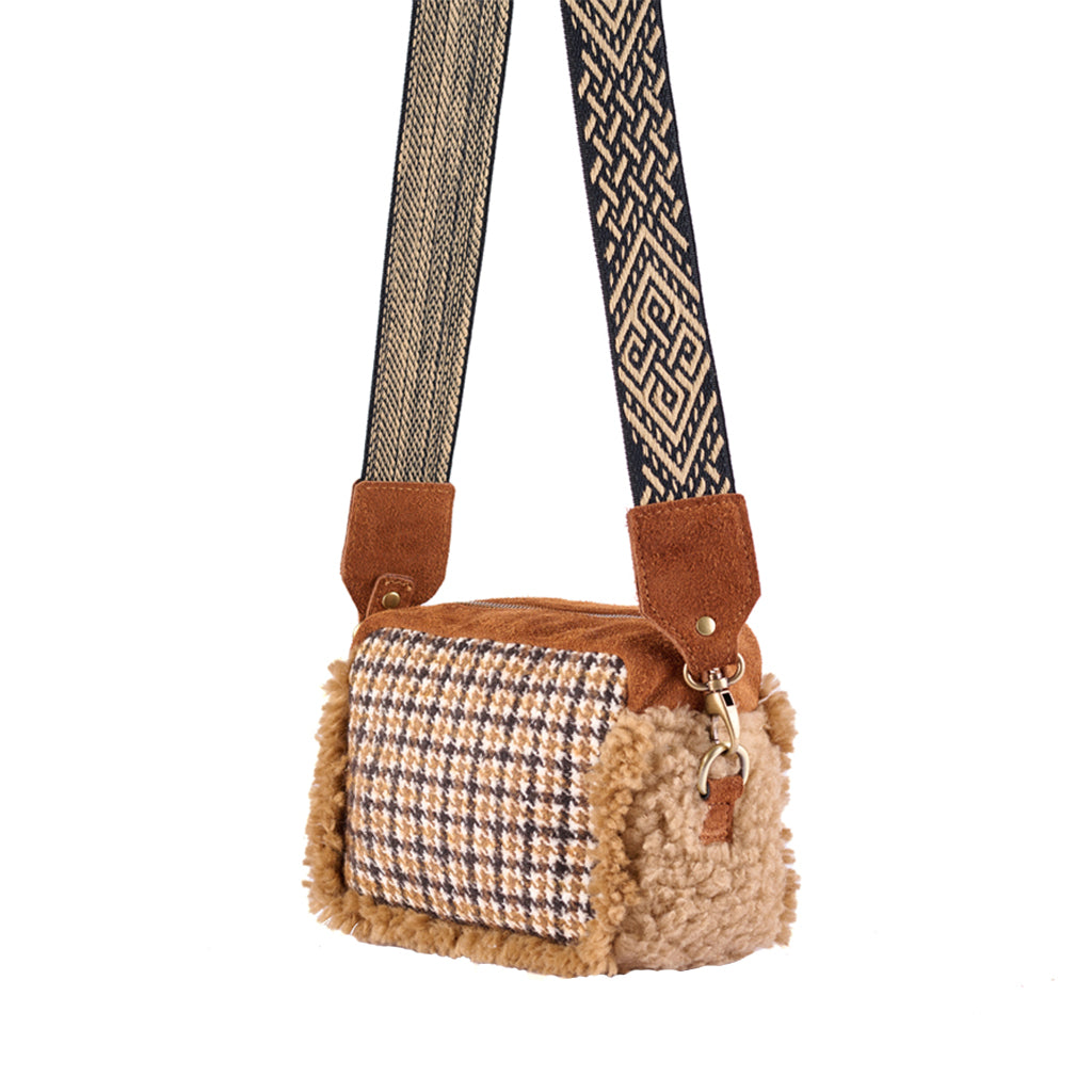 Houndstooth-patterned handbag with textured fur detailing and decorative strap