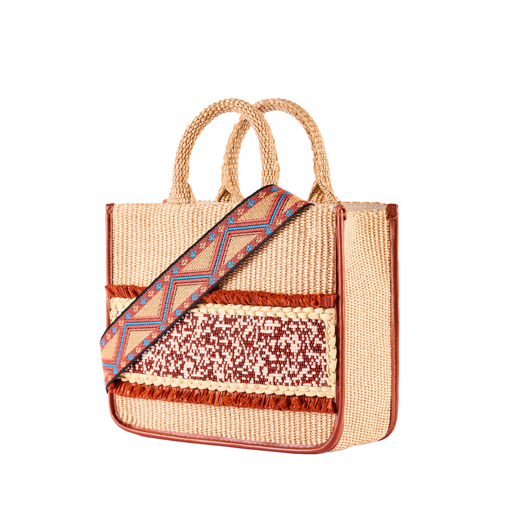 Woven straw handbag with colorful geometric strap and decorative accents in brown and red