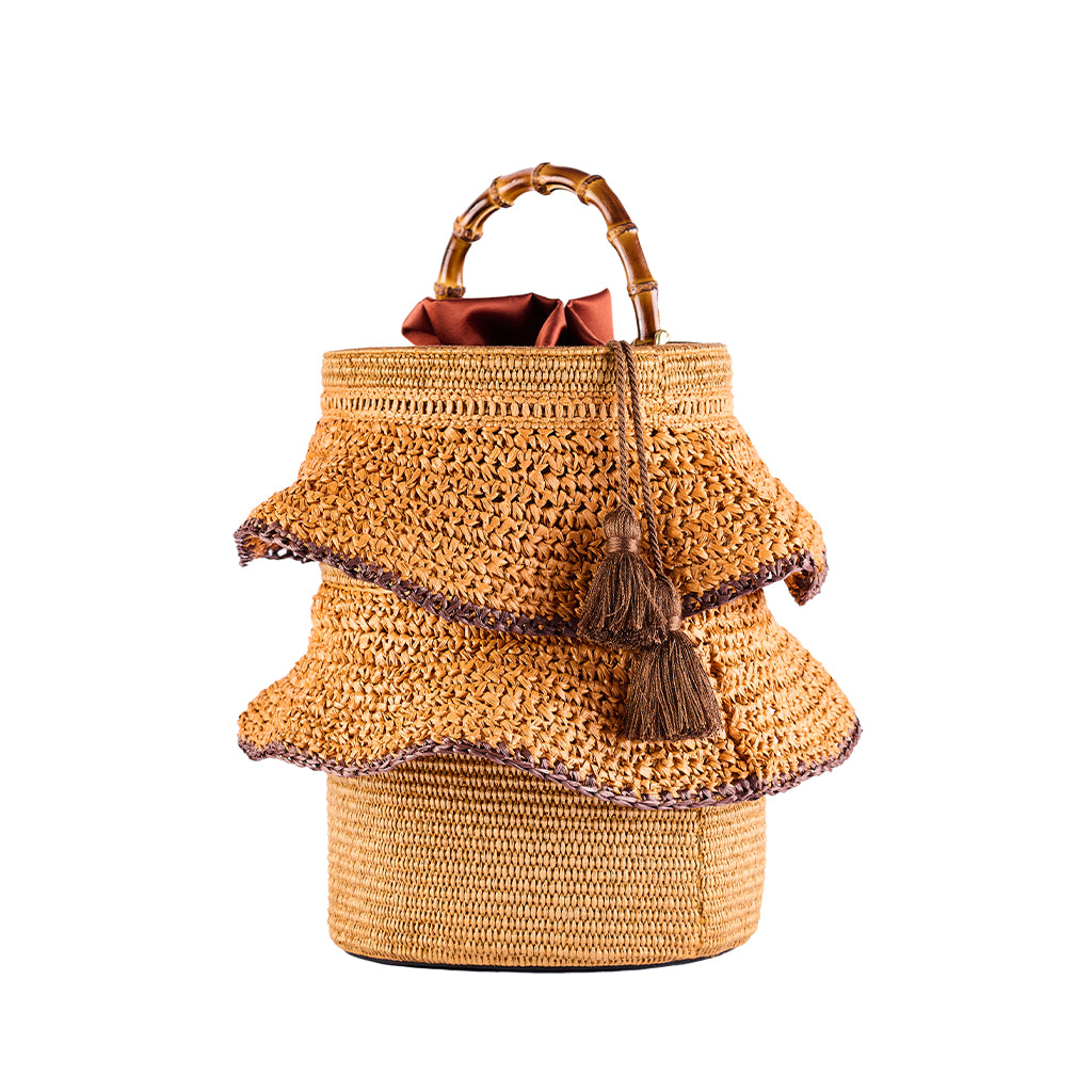 Handmade woven straw handbag with bamboo handle and decorative tassels