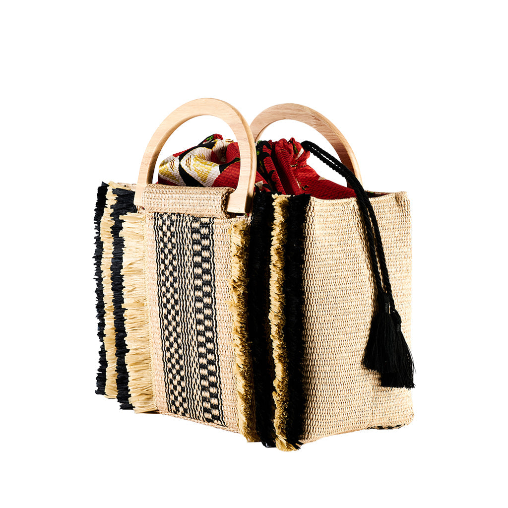 Handwoven straw tote bag with wooden handles and colorful interior fabric