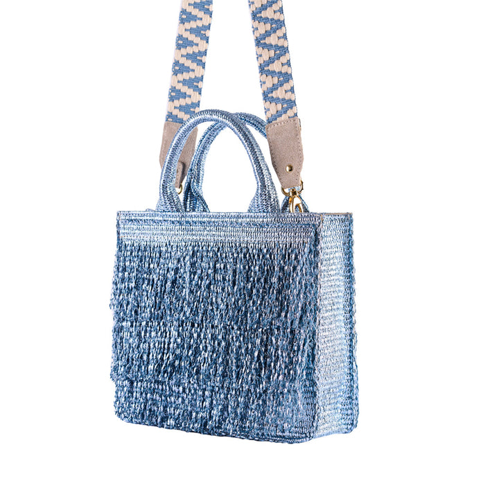 Light blue knitted handbag with patterned strap isolated on white background