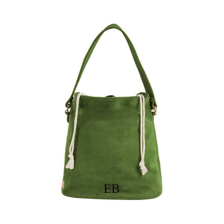 Green suede bucket bag with white drawstring and initials EB embroidered on the front
