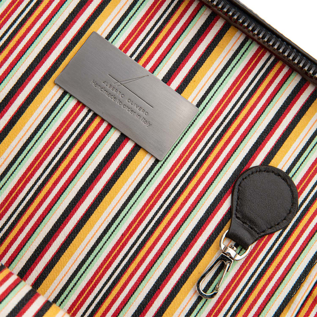 Close-up of colorful striped fabric with a black zipper and logo