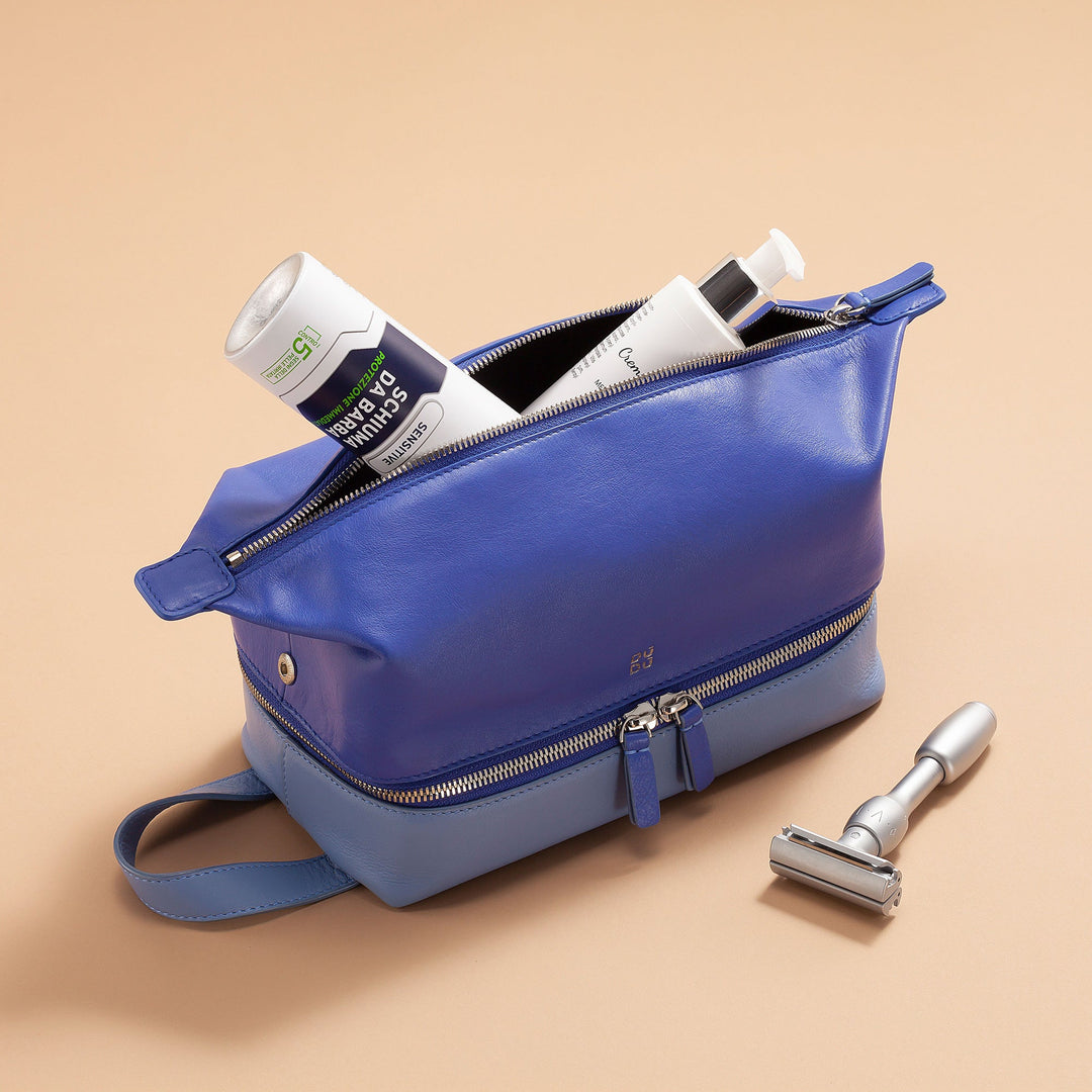 Blue leather toiletry bag with personal hygiene products and a razor