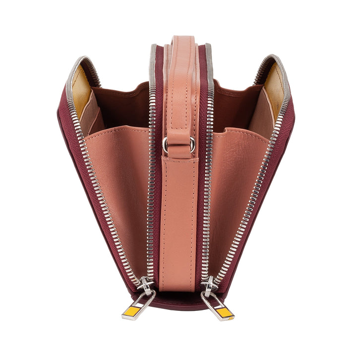 Top view of an open, pink and burgundy leather handbag with multiple compartments and dual zippers