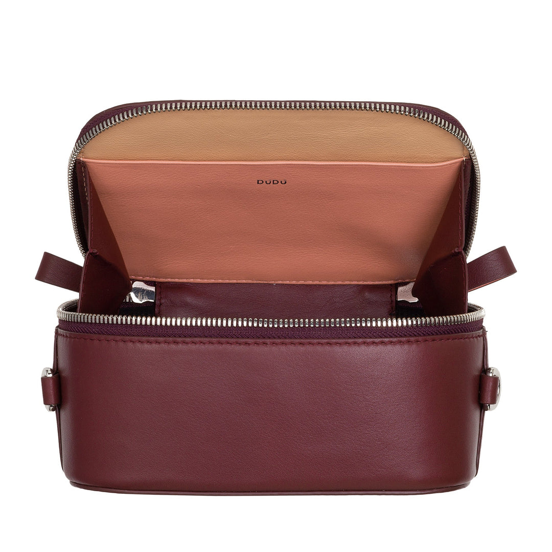 Open maroon leather handbag with beige interior and zipper detailing