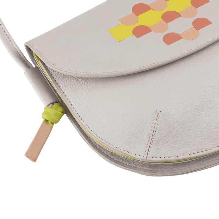 White leather handbag with colorful geometric pattern and yellow zipper pull