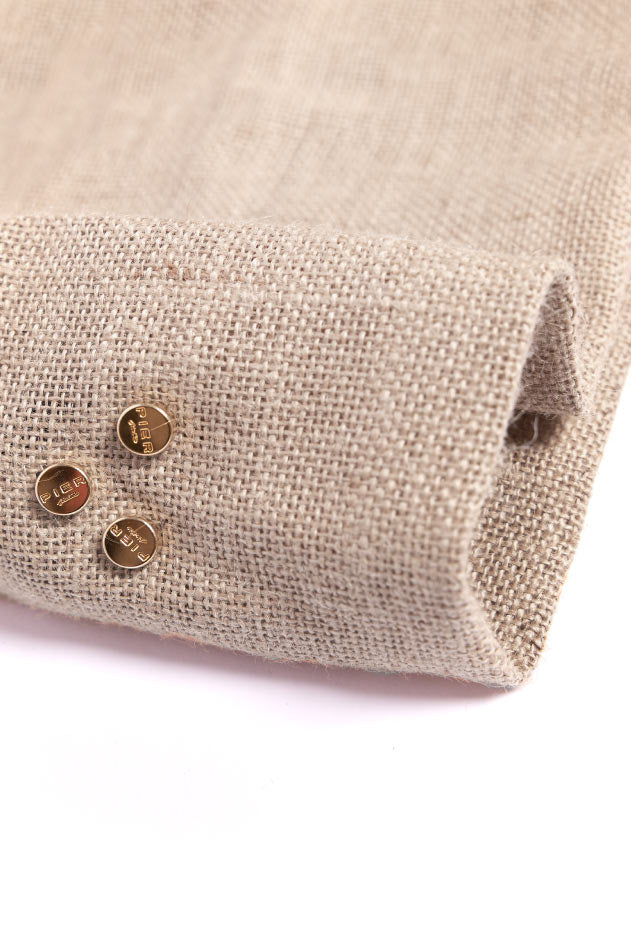 Close-up of beige burlap fabric with small gold-colored buttons