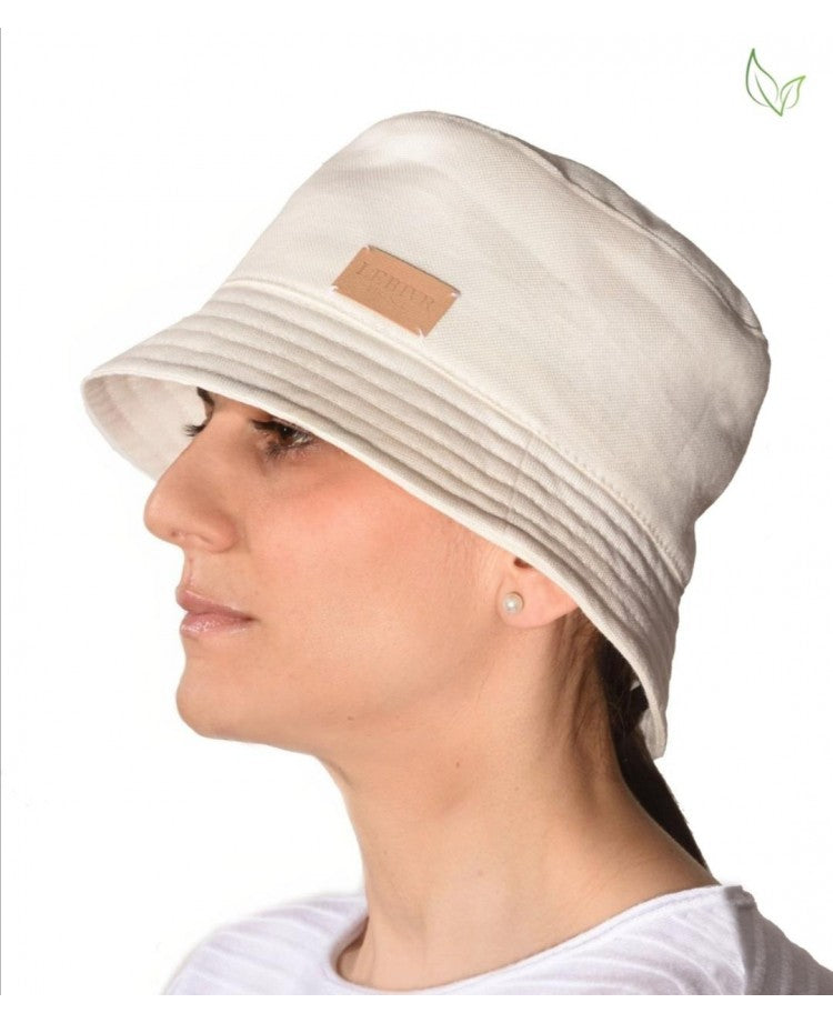 Woman wearing a white bucket hat with a logo tag