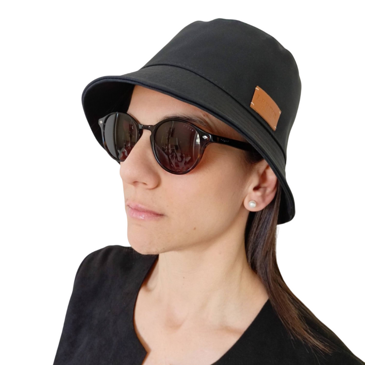 Woman wearing black bucket hat and sunglasses