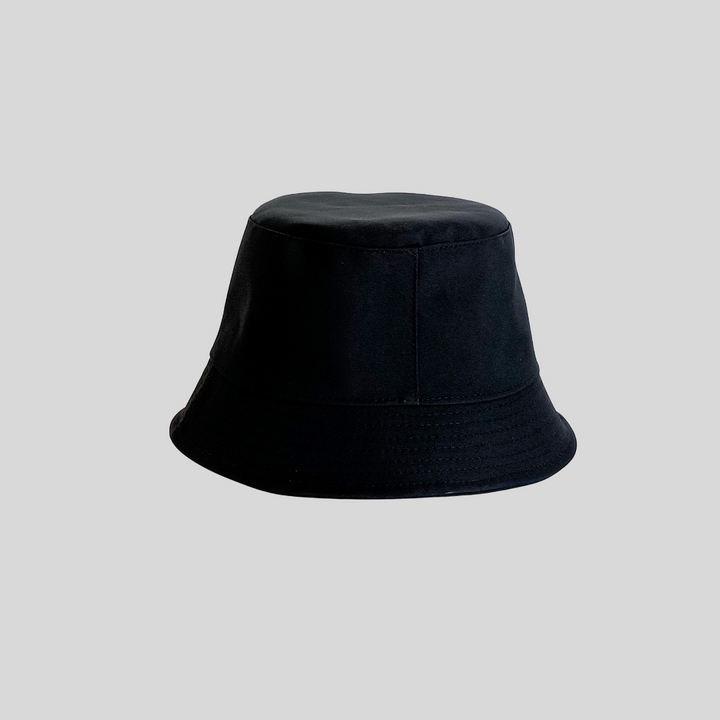 Black bucket hat on a plain grey background