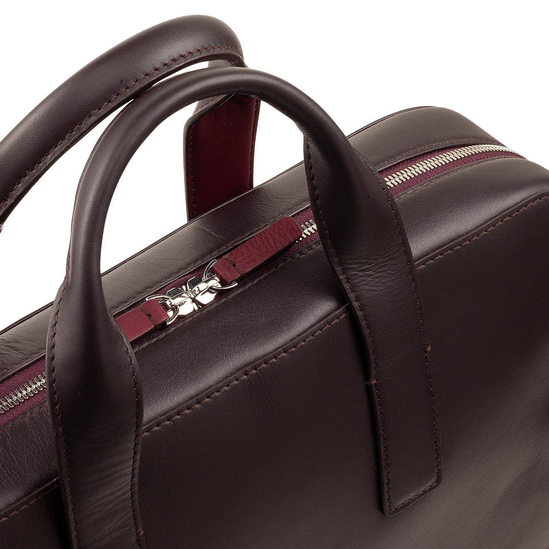 Close-up of a brown leather handbag with a silver zipper and handles