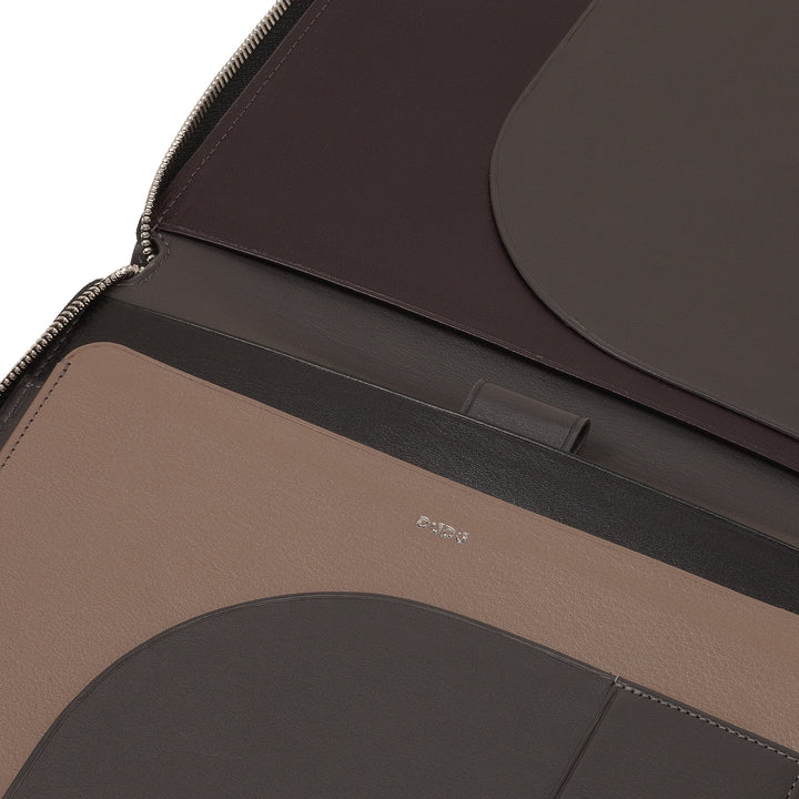 Close-up of a luxury leather laptop bag with multiple compartments and zipper closure