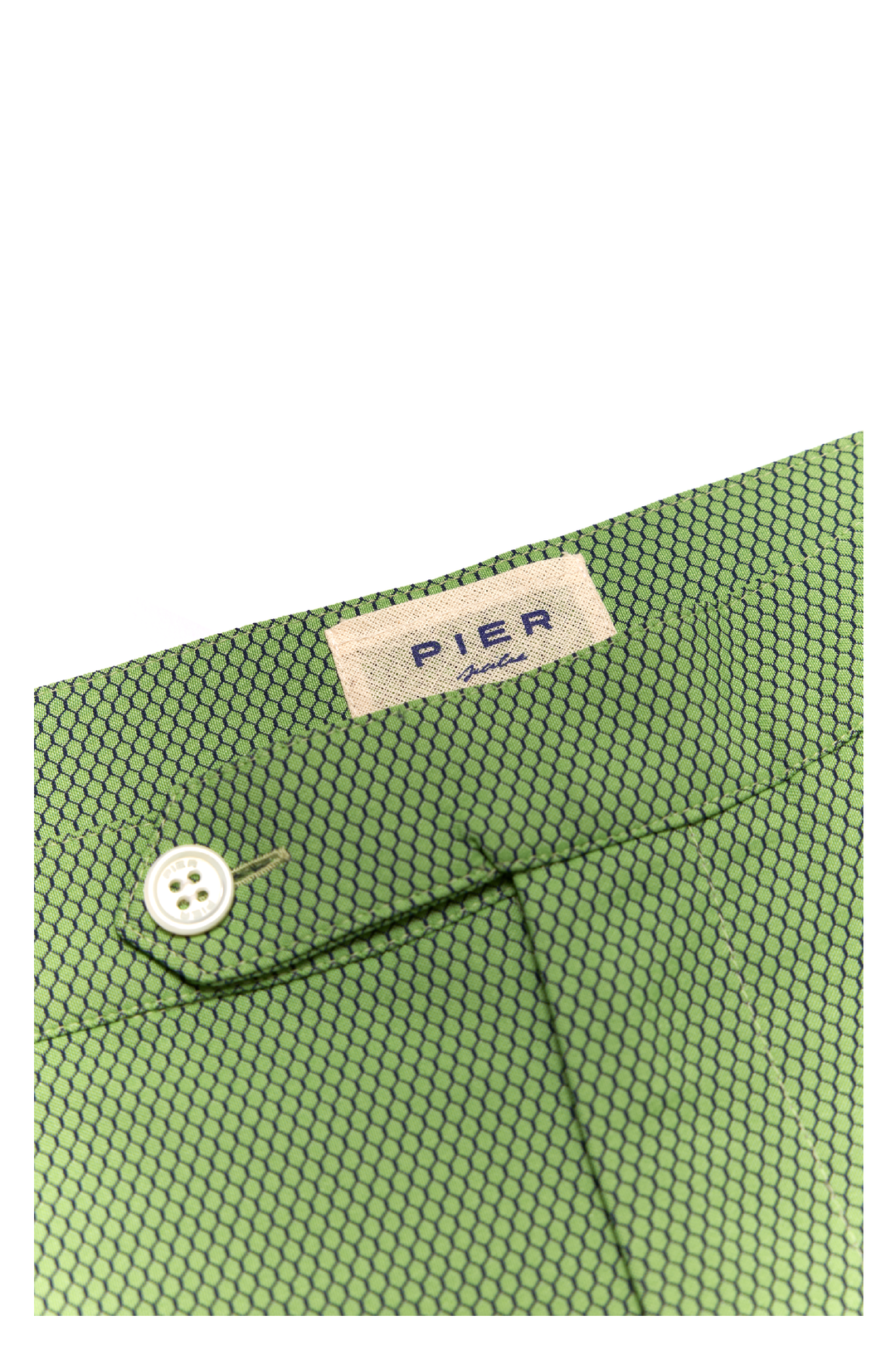 Close-up of green patterned pants with button and label