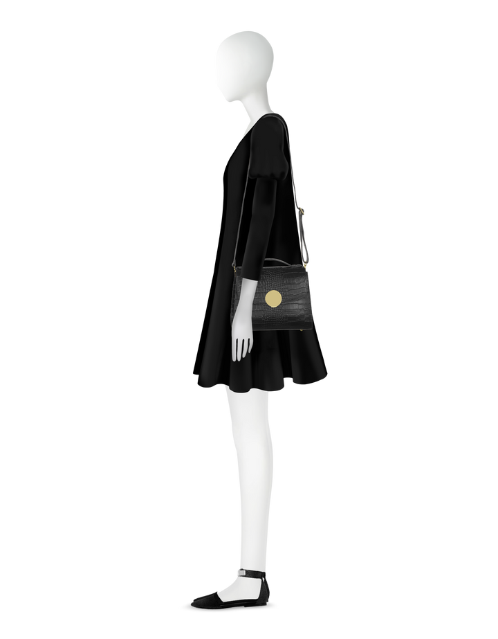 Mannequin in black dress with stylish handbag and pointed shoes