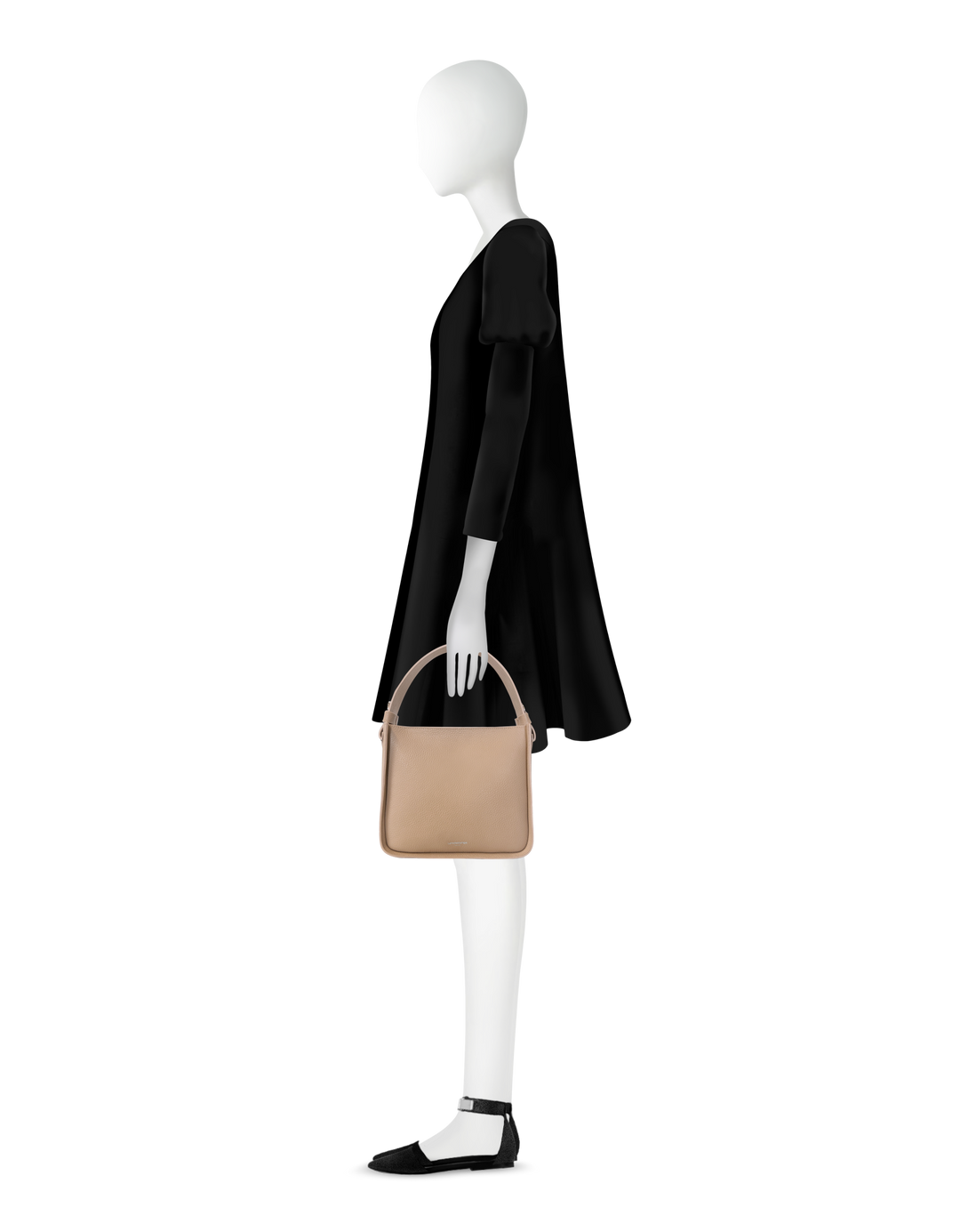 Elegant mannequin in black dress holding beige handbag