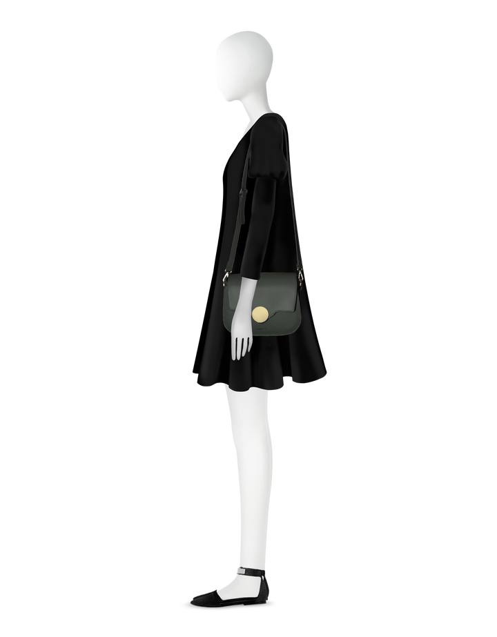 Side view of mannequin in black dress with green handbag