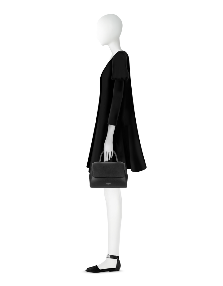 Elegant mannequin wearing black dress and holding black handbag