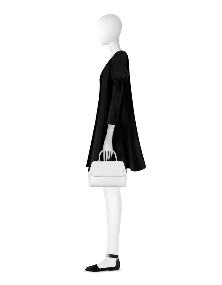 Fashion mannequin in black dress holding white handbag