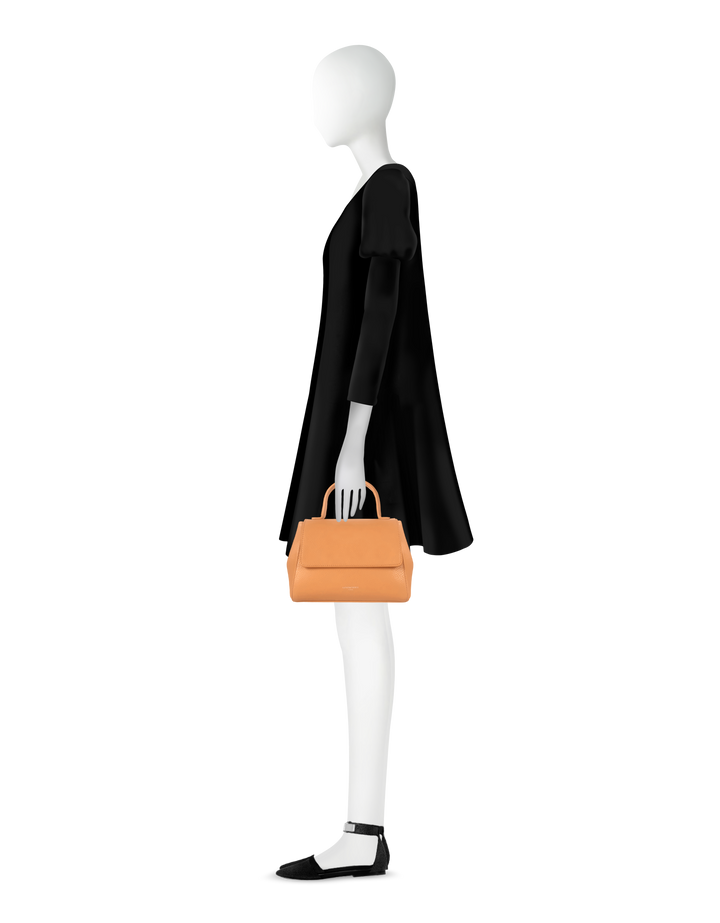 Silhouette of a mannequin in a black dress holding a stylish orange handbag