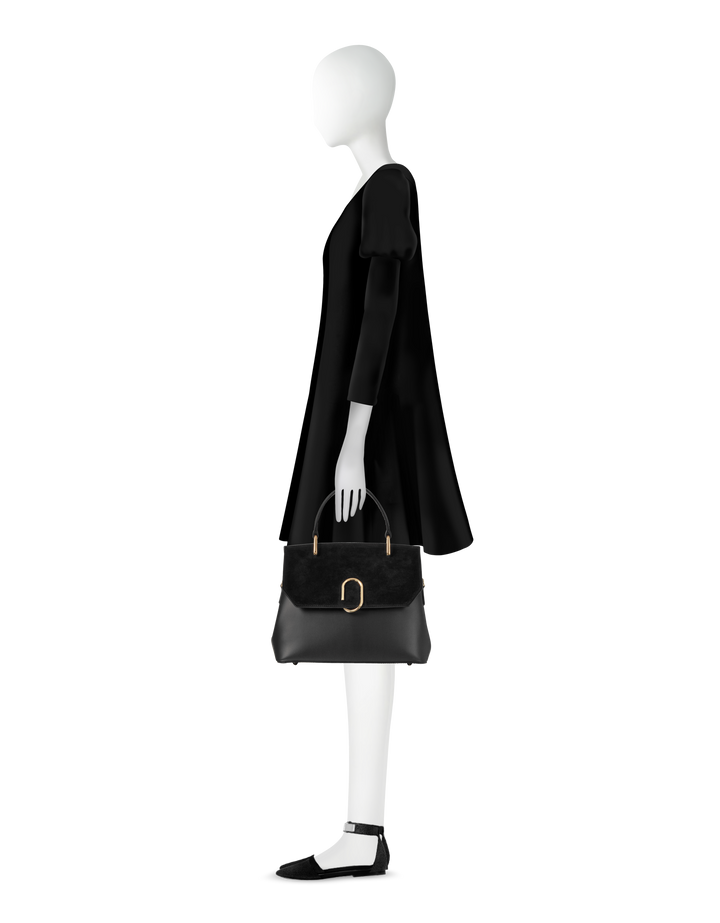Minimalist black dress with puff sleeves paired with black handbag and flats