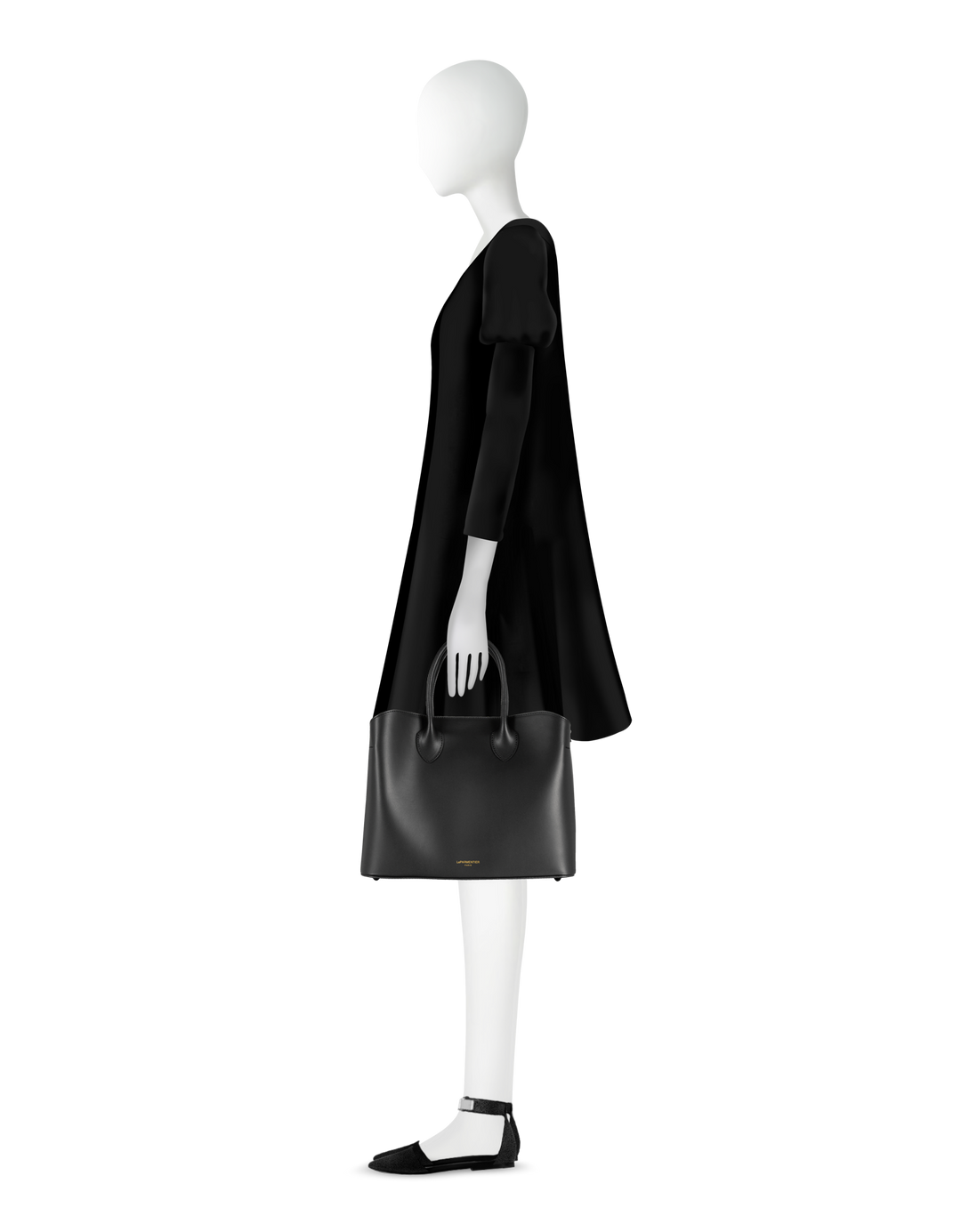 A mannequin dressed in a black dress holding a black handbag with ankle-strap shoes