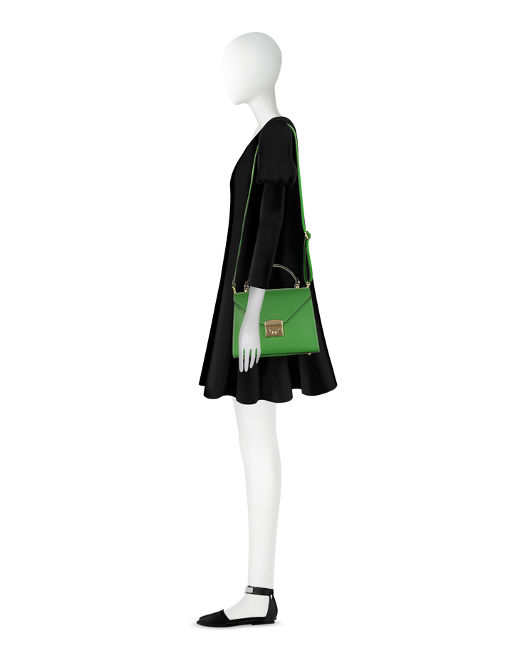 Woman in black dress holding a green handbag