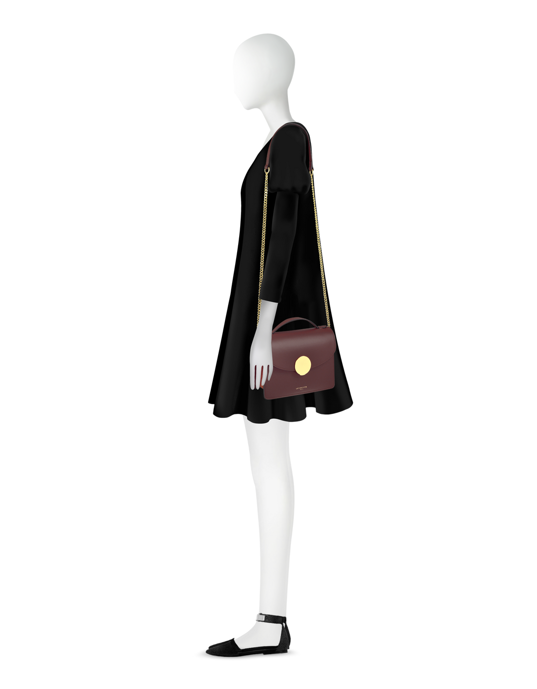 Side view of mannequin wearing a black dress with long sleeves paired with a maroon handbag and black shoes