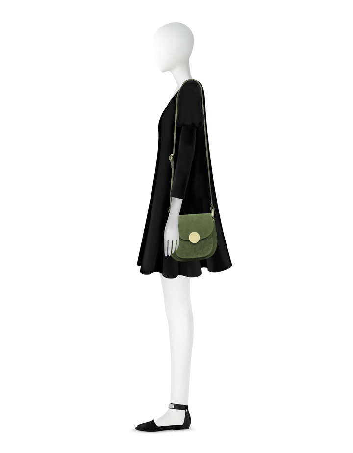 Side view of mannequin in black dress with green shoulder bag