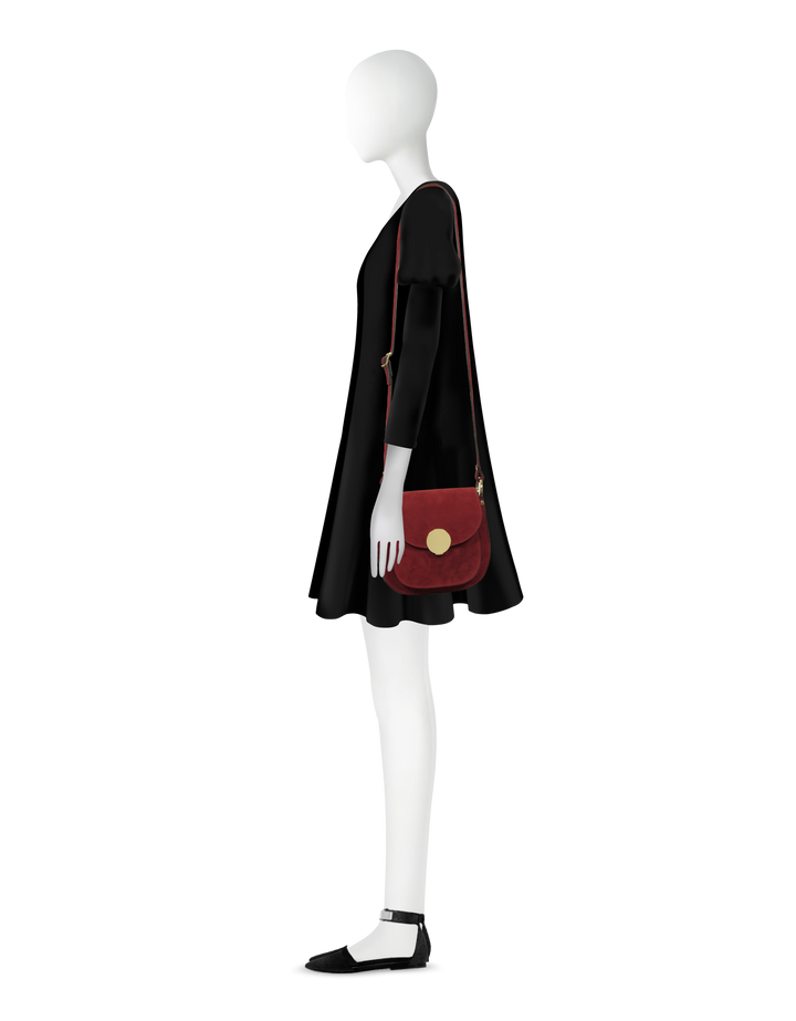 Side view of mannequin in black dress with maroon crossbody bag