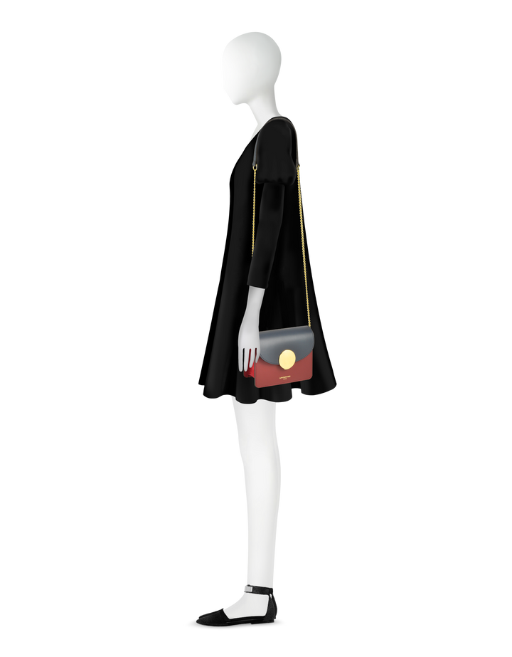 Fashionable mannequin in black dress holding a stylish shoulder bag