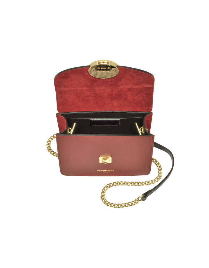 Luxury red leather handbag with gold chain strap and open flap revealing interior compartments