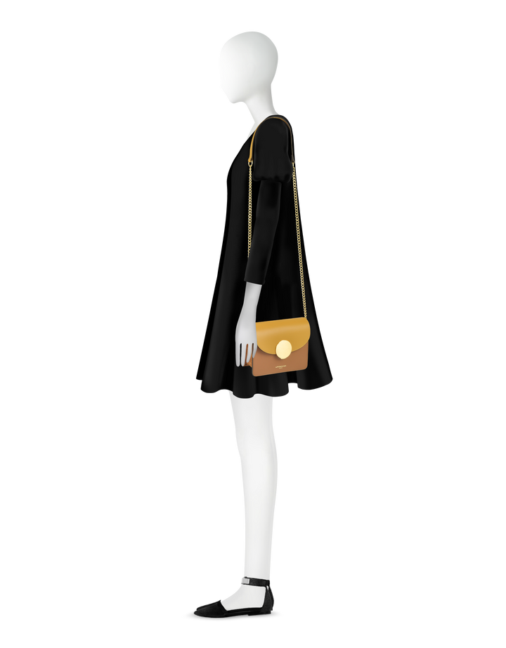 Profile of mannequin showcasing a black dress with a beige shoulder bag