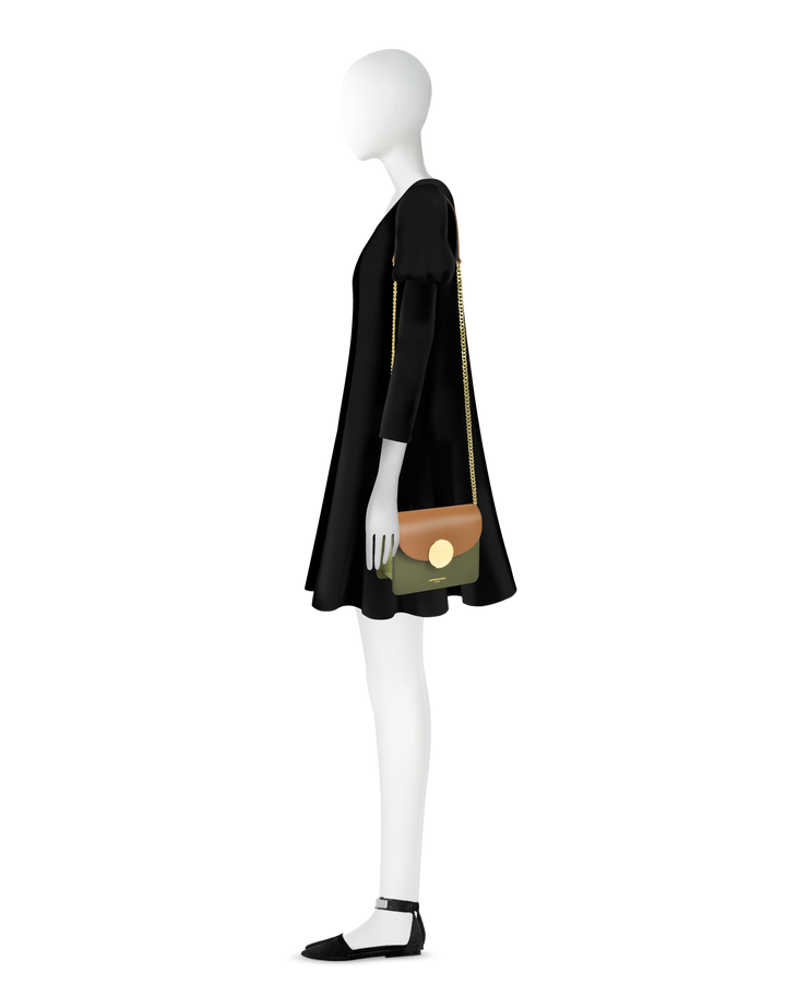 Minimalist mannequin in black dress holding a chic, multicolored handbag with gold chain strap