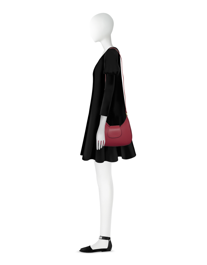 Side view of a mannequin wearing a black dress and carrying a red shoulder bag