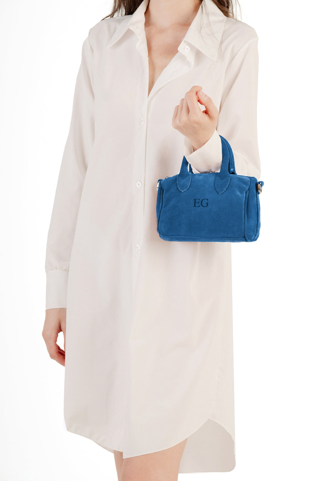 Woman in white dress holding a blue handbag