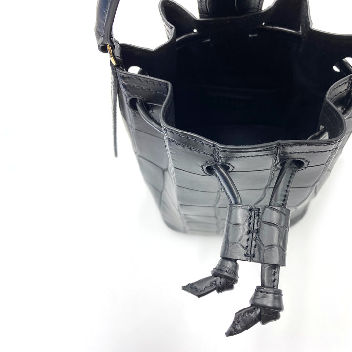 Top view of a black leather drawstring handbag with croc-embossed texture