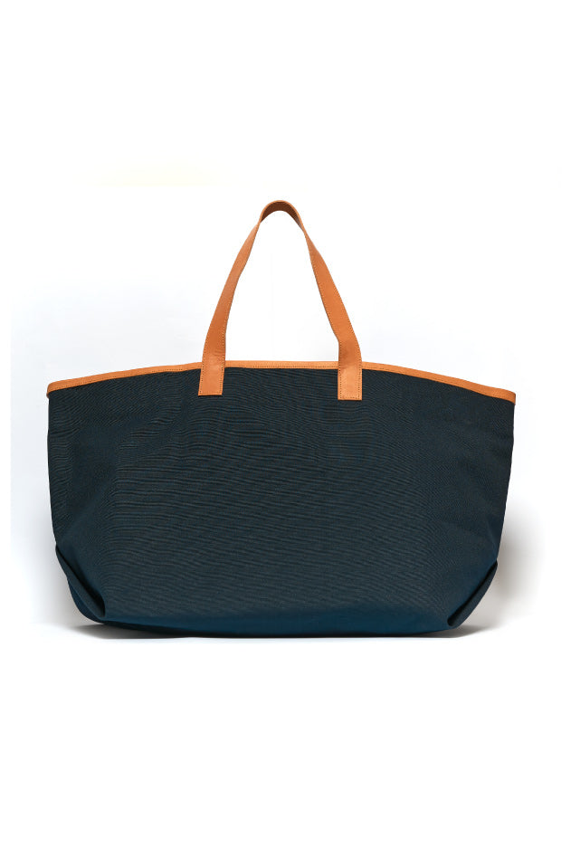 Large dark blue tote bag with tan handles on white background