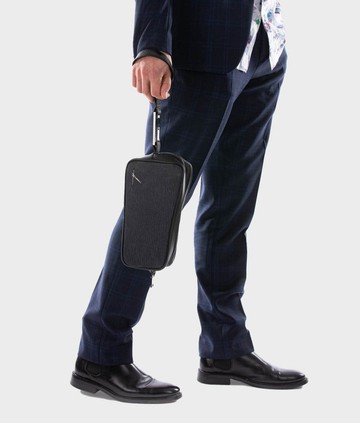 Man in a suit holding a black leather travel case