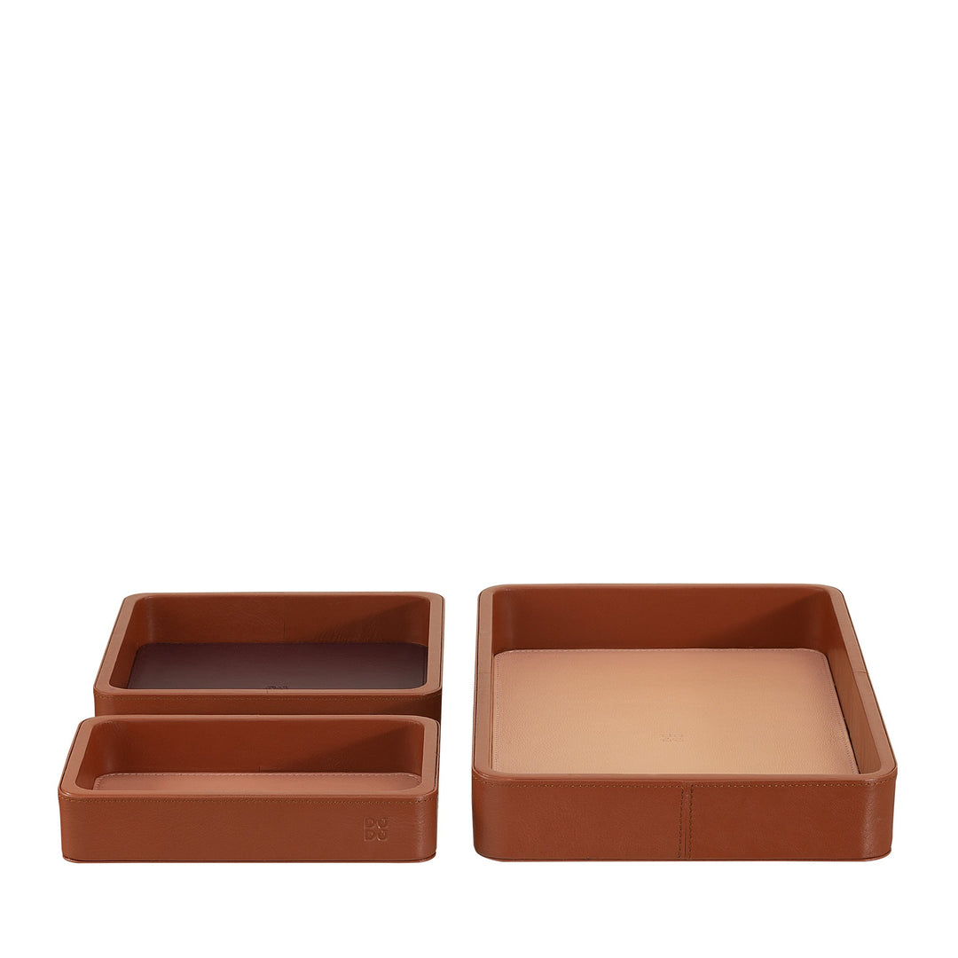 Set of three brown leather trays in varying sizes