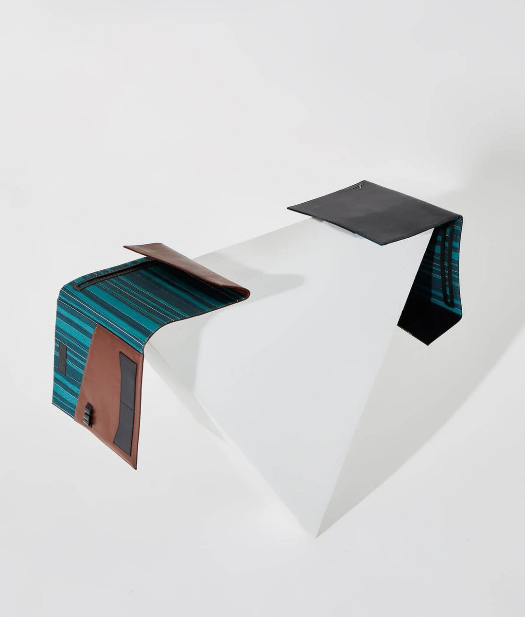 Modern abstract sculpture with geometric shapes and contrasting materials on a white background